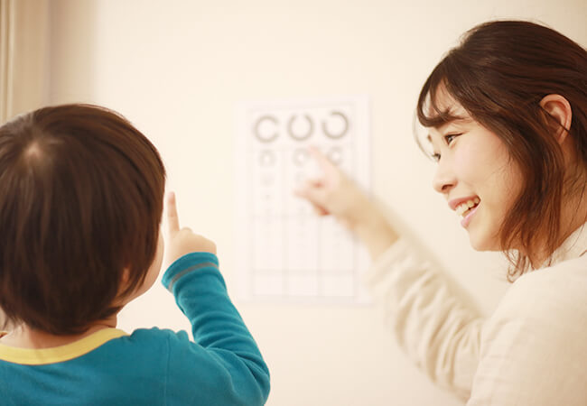 視力検査を行う女性と子ども